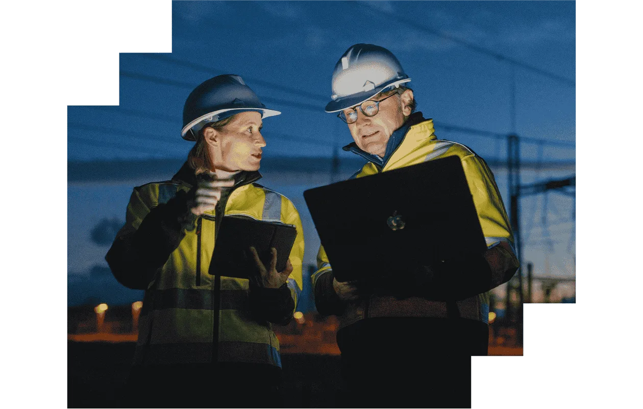 Woman and man on construction site holding laptops
