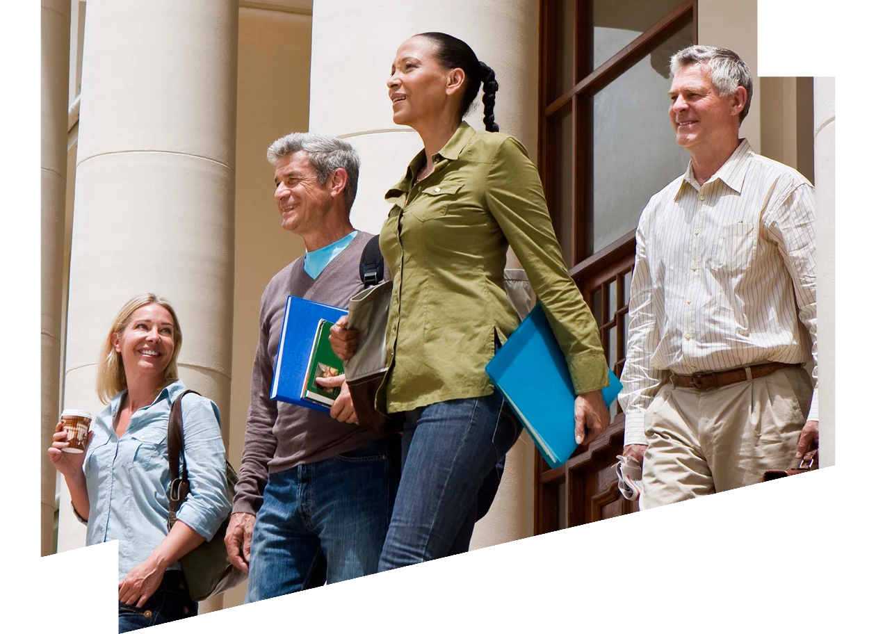 A group of people ascending the steps of a building, engaged in conversation.